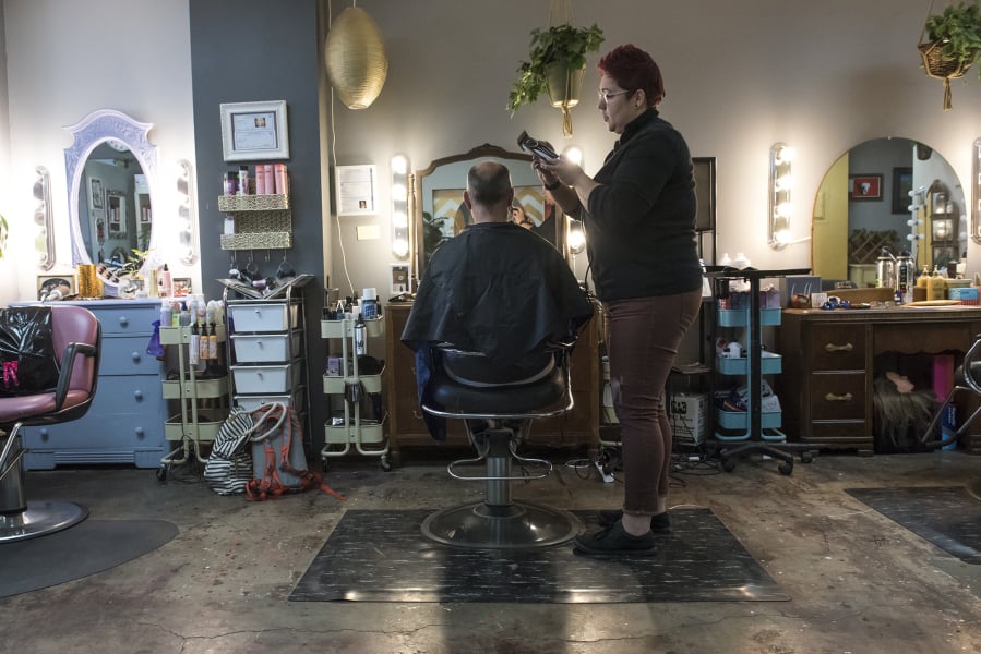 One of the perks of being an independent hairstylist is getting to pick your clients. Shelby Oxley cuts the hair of her husband, Barry Oxley, at the station she rents in Marquee Salon + Studio.