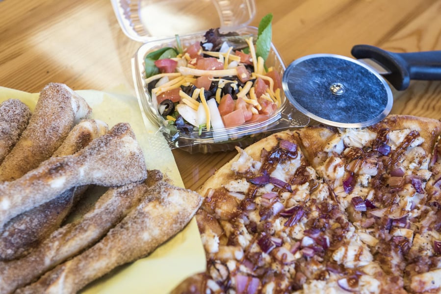 Cinnamon sugar sticks, from left, the garden salad and a Half & Half Signature Pizza combination of the Dough Boys Classic Cheese and Memphis BBQ.