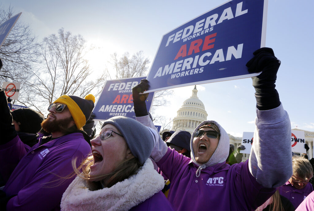 On the 20th day of a partial government shutdown, federal employees rally at the Capitol to protest the impasse between Congress and President Donald Trump over his demand to fund a U.S.-Mexico border wall, in Washington, Thursday,  Jan. 10, 2019. (AP Photo/J.