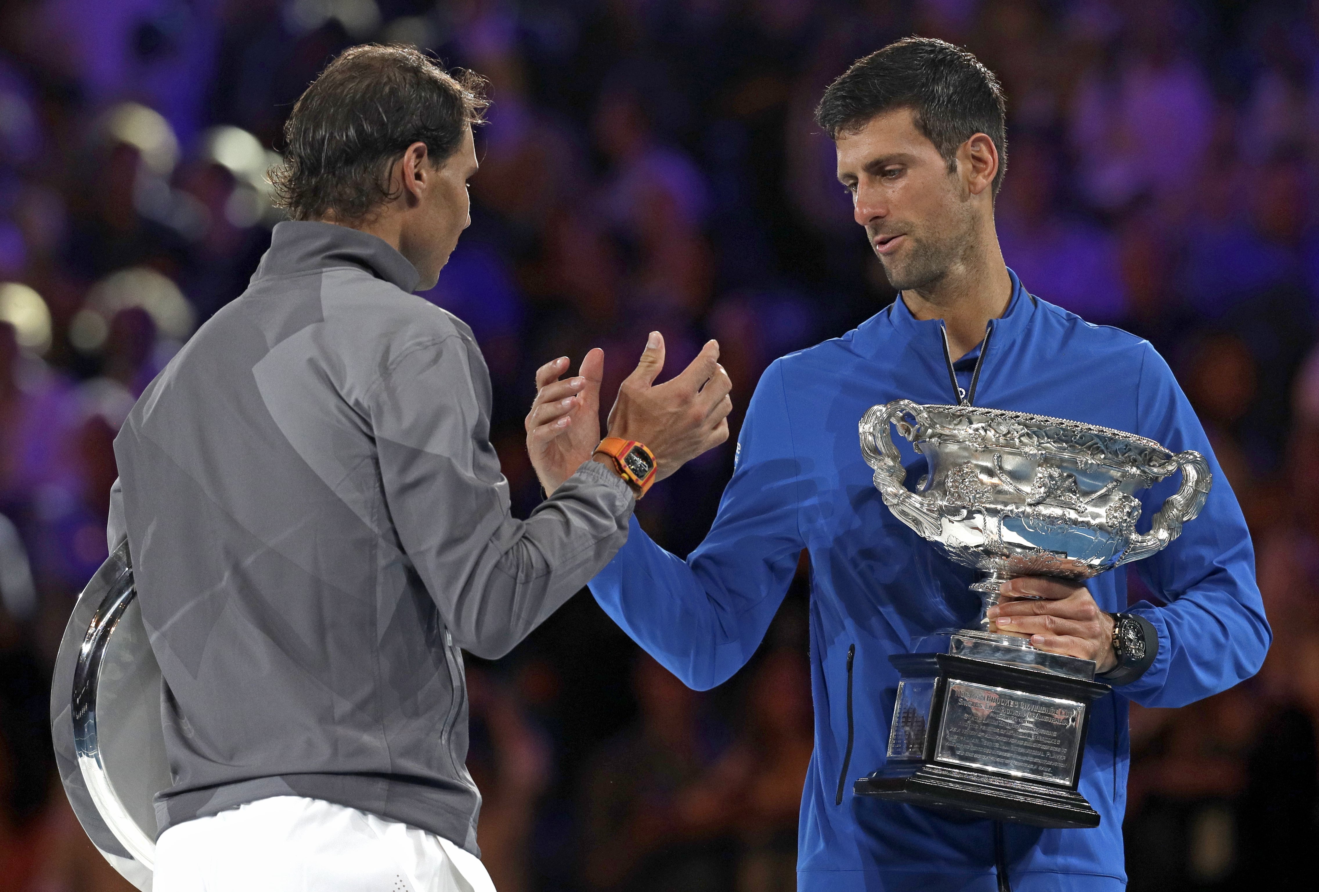 Serbia's Novak Djokovic, right, shakes hands with Spain's Rafael Nadal on the podium after winning the men's singles final at the Australian Open tennis championships in Melbourne, Australia, Sunday, Jan. 27, 2019.
