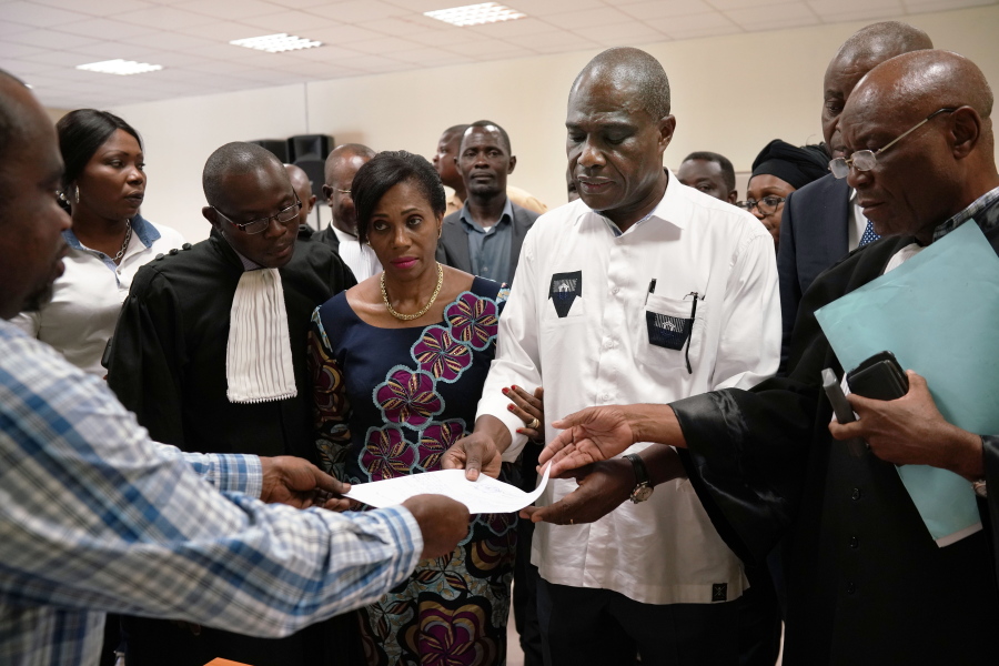 Accompanied by his wife and his lawyers, Congo opposition candidate Martin Fayulu receives the receipt after petitioning the constitutional court following his loss in the presidential elections in Kinshasa, Congo, Saturday Jan. 12, 2019. The ruling coalition of Congo’s outgoing President Joseph Kabila has won a large majority of national assembly seats, the electoral commission announced Saturday, while the presidential election runner-up was poised to file a court challenge alleging fraud.