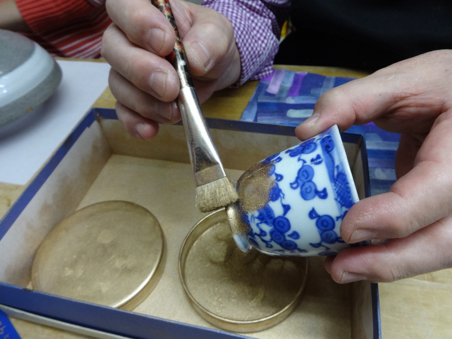 The final step of kintsugi involves gold dust being brushed on to the repaired crack at the Kuge Crafts workshop in Tokyo on Nov. 11.
