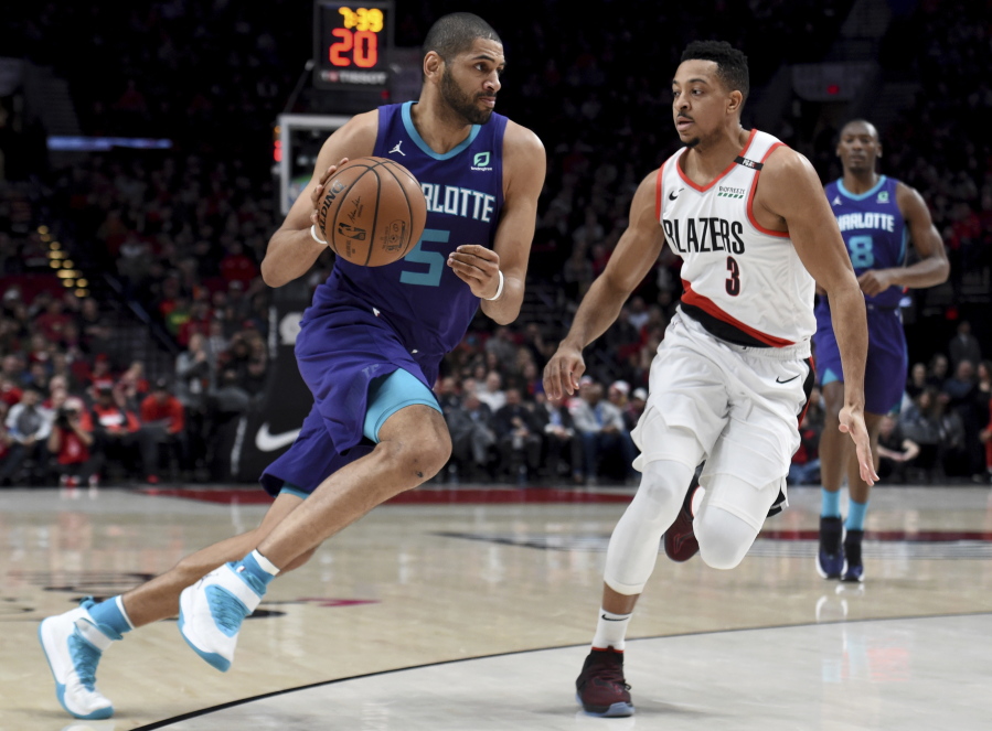 Charlotte Hornets forward Nicolas Batum, left, drives to the basket on Portland Trail Blazers guard CJ McCollum, right, during the first half of an NBA basketball game in Portland, Ore., Friday, Jan. 11, 2019.