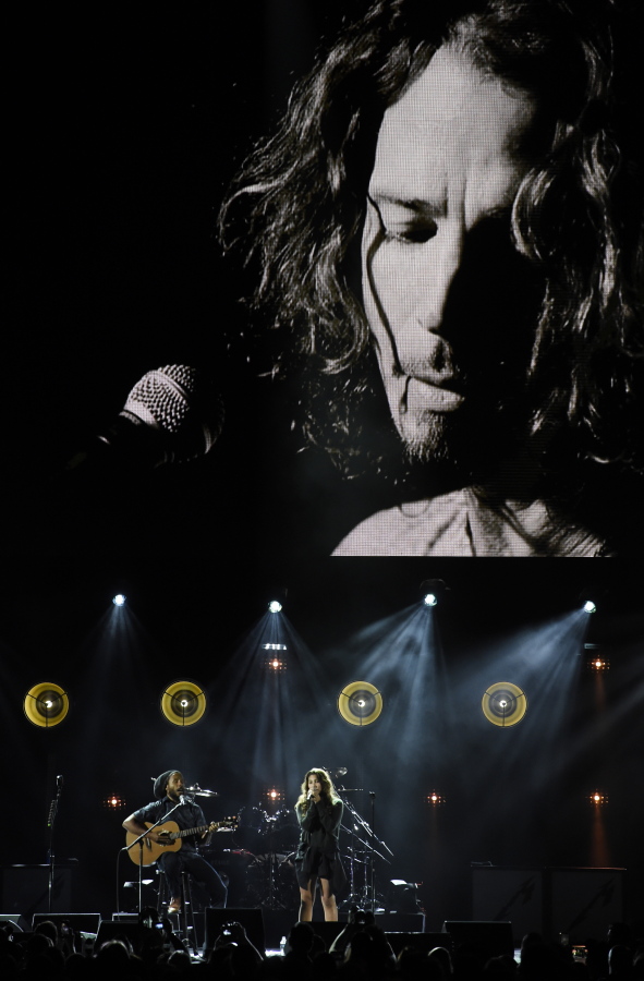 Toni Cornell, daughter of the late singer Chris Cornell, performs with Ziggy Marley, bottom left, underneath a video image of her father during “I Am The Highway: A Tribute to Chris Cornell” at The Forum, Wednesday, Jan. 16, 2019, in Inglewood, Calif.