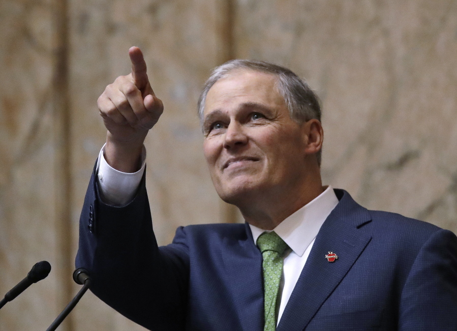 Gov. Jay Inslee points toward the gallery above where his family sits at the conclusion of his State of the State address Jan. 15 in Olympia. Inslee, who is mulling a 2020 White House bid, highlighted his clean energy agenda in the annual speech.