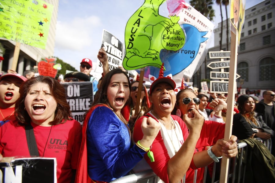 Elementary school teachers Iris Marin, second from left, center, and Mireya Gutierrez, right, and Lorena Redford, rally in downtown Los Angeles, Friday, Jan. 18, 2019. Teachers picketed and rallied Friday as a strike against the giant Los Angeles Unified School District entered its fifth day with a new round of contract negotiations underway.