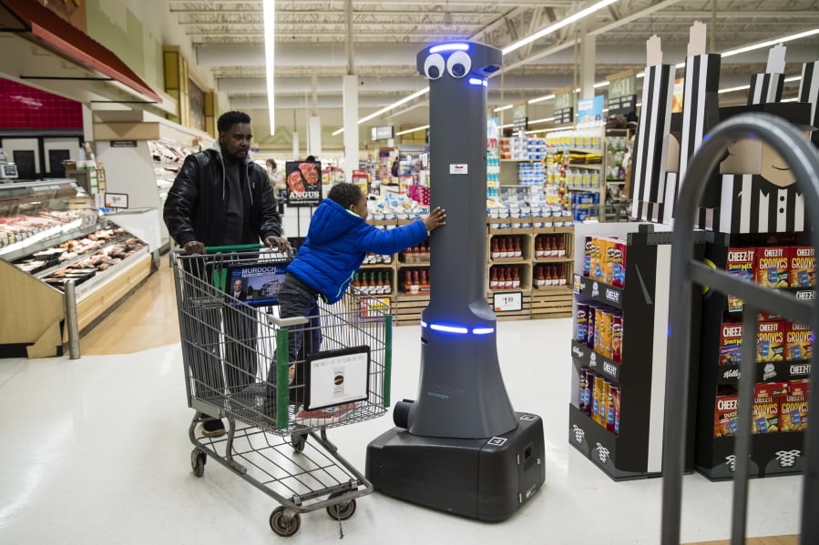 William Rucker and his grandson Justice, 4, say hello to a robot named Marty as it cleans the floors at a Giant grocery store in Harrisburg, Pa.