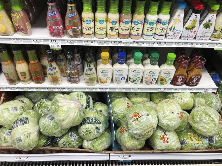 Regular iceberg lettuce, lower left, selling at $3.19 each, is displayed next to organic iceberg lettuce, selling at $4.19 each, at a grocery store in North Miami, Fla.