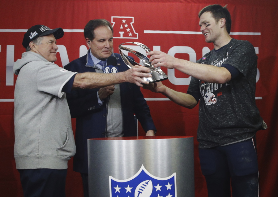 New England Patriots head coach Bill Belichick, left, hands off the championship trophy to quarterback Tom Brady after defeating the Kansas City Chiefs in the AFC Championship NFL football game, Sunday, Jan. 20, 2019, in Kansas City, Mo.