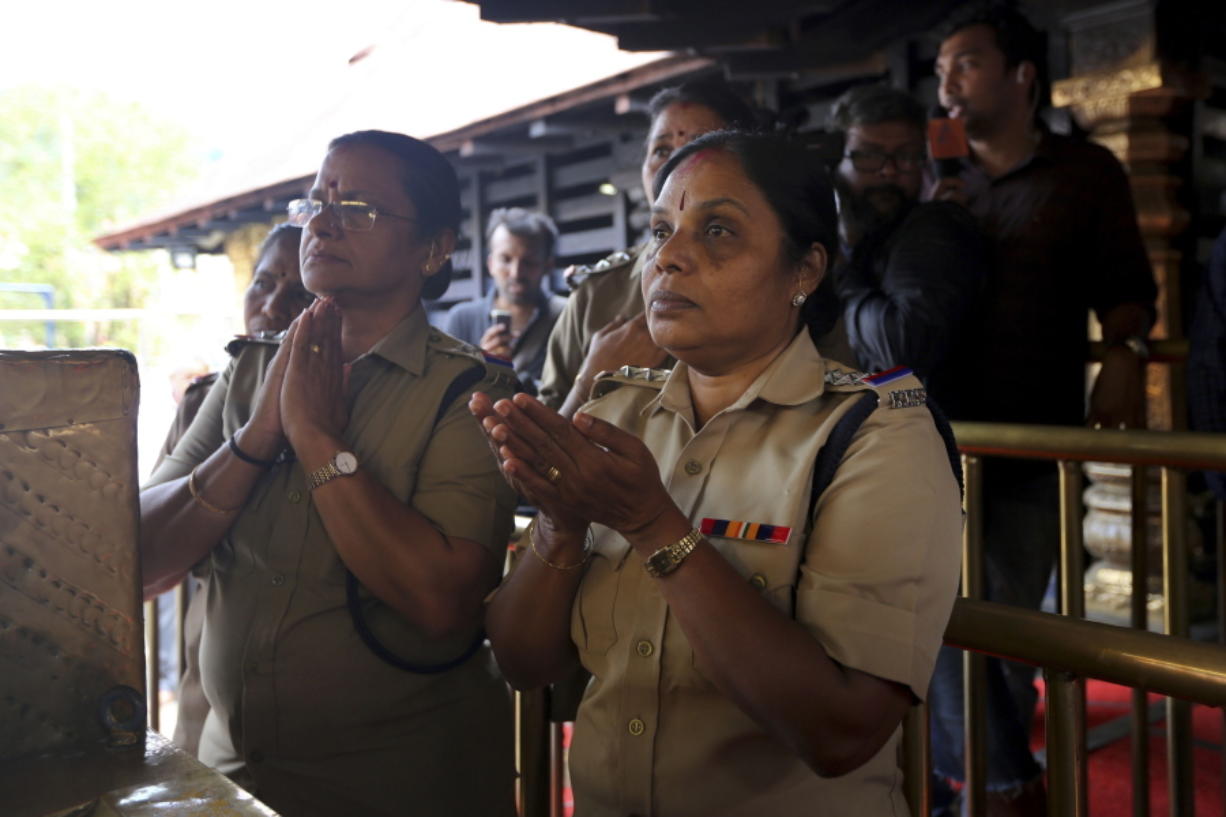 FILE - In this Nov. 5, 2018 file photo, police officers, who are above the age of 50, pray at the Sabarimala temple, one of the world’s largest Hindu pilgrimage sites, in the southern Indian state of Kerala. The historic temple had barred women age 10 to 50 from entering the temple.