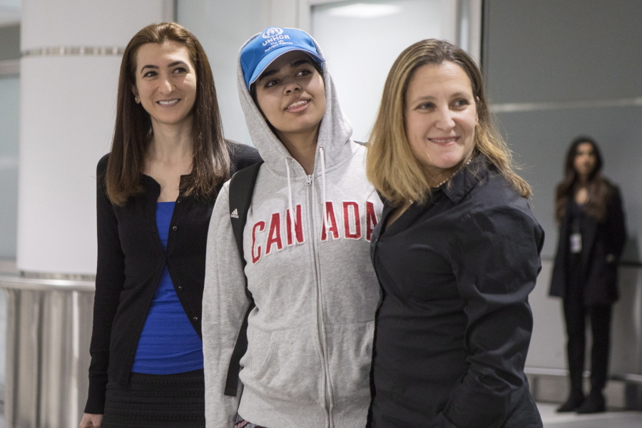 Rahaf Mohammed Alqunun, 18, center, stands with Canadian Minister of Foreign Affairs Chrystia Freeland, right, as she arrives at Toronto Pearson International Airport, on Saturday, Jan.12, 2019. The Saudi teen fled her family while visiting Kuwait and flew to Bangkok, where she barricaded herself in an airport hotel and launched a Twitter campaign that drew global attention to her case. Prime Minister Justin Trudeau announced his government would accept her as a refugee.