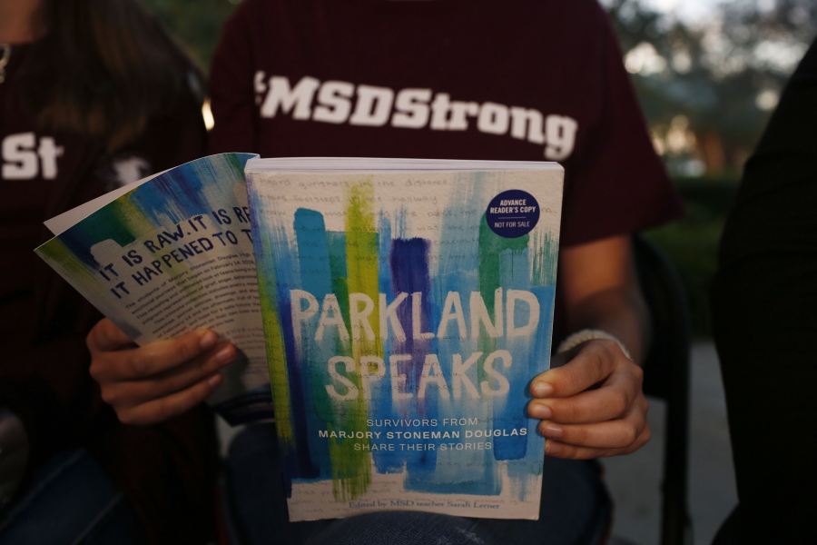 In this Wednesday, Jan. 16, 2019, photo, Leni Steinhardt, 16, reads from a new book called “Parkland Speaks: Survivors from Marjory Stoneman Douglas Share Their Stories,” during an interview with The Associated Press, in Parkland, Fla.