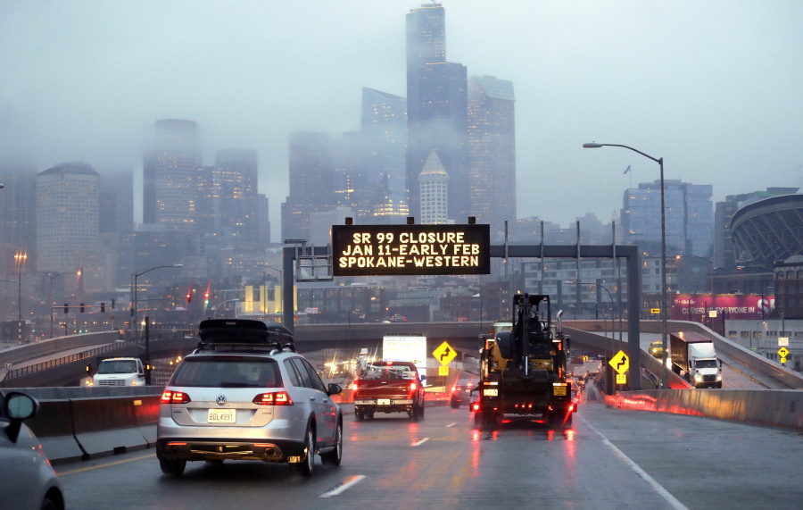 Rush hour northbound Highway 99 traffic backs-up Jan. 3 while heading toward the Alaskan Way Viaduct just ahead as a sign overhead advises of an upcoming closure of the roadway in Seattle.