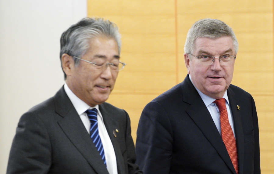FILE - In this Nov. 30, 2018, file photo, International Olympic Committee (IOC) President Thomas Bach, right, escorts Japanese Olympic Committee (JOC) President Tsunekazu Takeda during an IOC Executive Board meeting in Tokyo. France’s financial crimes office says International Olympic Committee member Takeda is being investigated for corruption related to the 2020 Tokyo Olympics. The National Financial Prosecutors office says Takeda, the president of the Japanese Olympic Committee, was placed under formal investigation for “active corruption” on Dec.