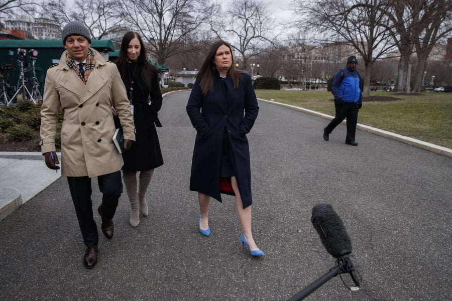 White House press secretary Sarah Huckabee Sanders walks to speak with reporters outside the White House, Wednesday, Jan. 23, 2019, in Washington.