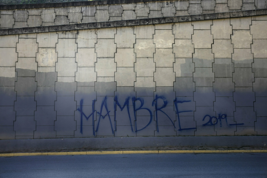 Graffiti that reads in Spanish: “Hunger 2019” covers a highway wall in Caracas, Venezuela, Sunday, Jan. 27, 2019. Venezuelans are struggling with hyperinflation and widespread food shortages.