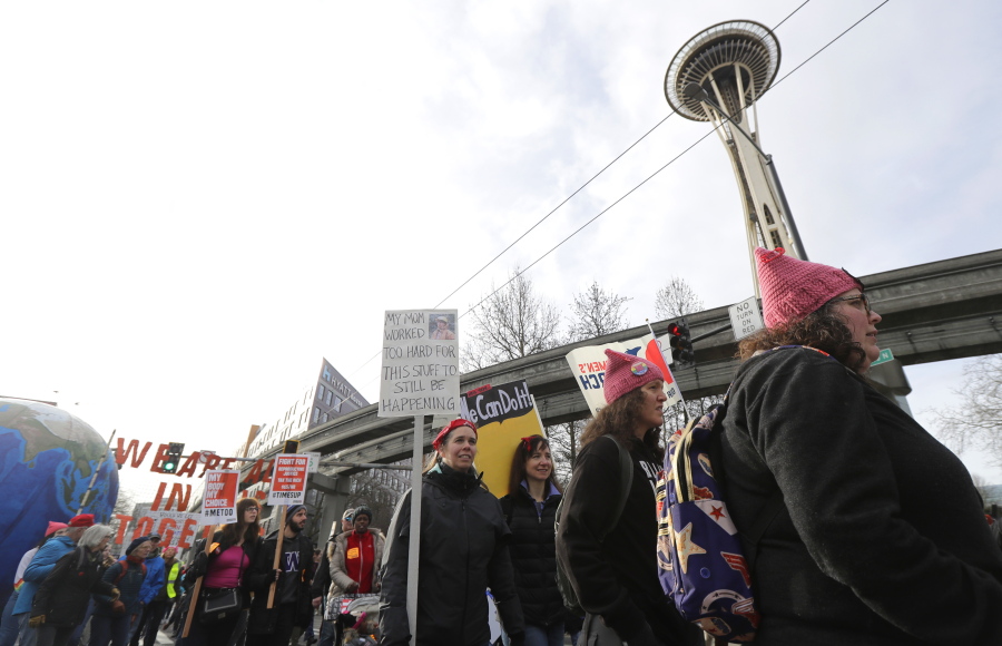 Women wearing pink hats walk past the Space Needle as they take part in the Women's March in Seattle, Saturday, Jan. 19, 2019. Cities big and small across the Pacific Northwest held versions or multiple versions of the Women's March over the weekend, mirroring a national march in Washington, DC. (Ted S.