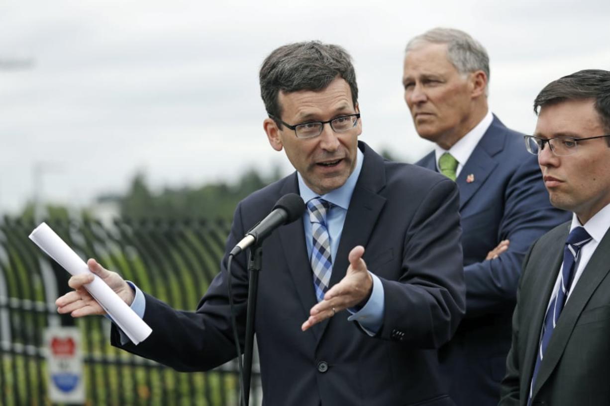 Attorney General Bob Ferguson, left, speaks as Washington Gov. Jay Inslee, center, and Solicitor General Noah Purcell look on at a news conference announcing a lawsuit against the Trump administration over a policy of separating immigrant families illegally entering the United States, in front of the Federal Detention Center in SeaTac, Wash.