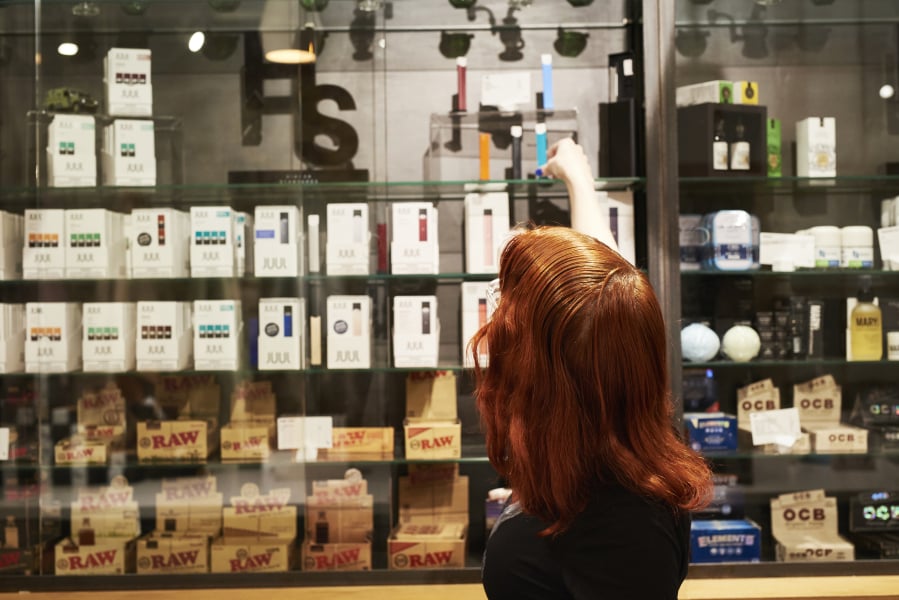 An employee organizes Juul Labs e-cigarettes displayed for sale Dec. 11 at the Higher Standards store in Chelsea Market in New York.