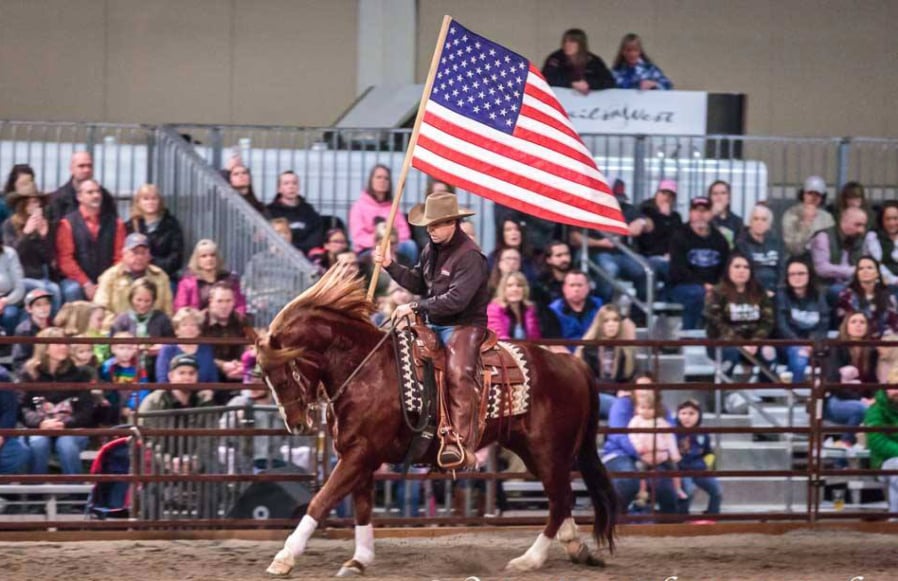 Horse expert Steve Rother carries a flag around the arena at the Washington Horse Expo. Wes Dot Photography.