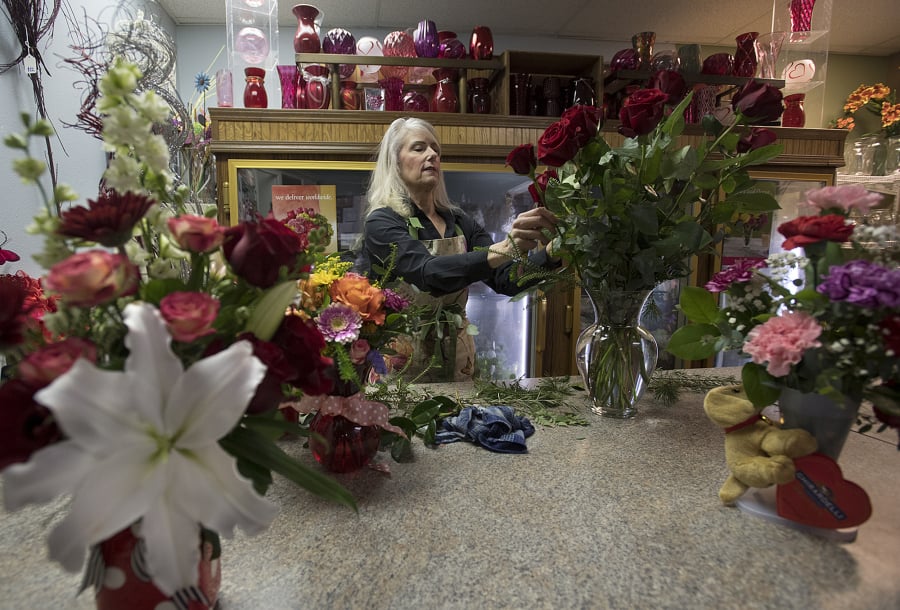 Florist Jane BonVillain arranges a vase of red roses at Ridgefield Floral & Gifts. Though Ridgefield is her hometown, she began her floral career working in a shop in Manhattan and returned to Clark County to be closer to her mother.