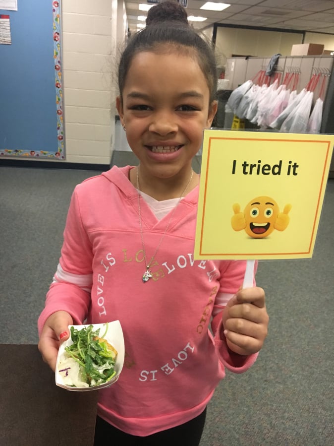 North Image: Lauren Lu, Image Elementary School student, with her kale Caesar salad. Kale was the featured ingredient in the month Harvest of the Month program from Washington State University Extension’s Supplemental Nutrition Assistance Program Education and Evergreen Public Schools’ Chartwells food service.