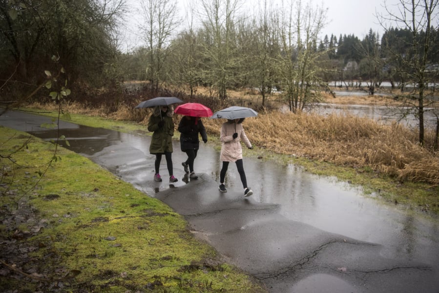 Terry McDowell, center, walks Tuesday along the Salmon Creek Greenway Trail with her daughters Marisa, left, and Chloe, 16, in Vancouver.