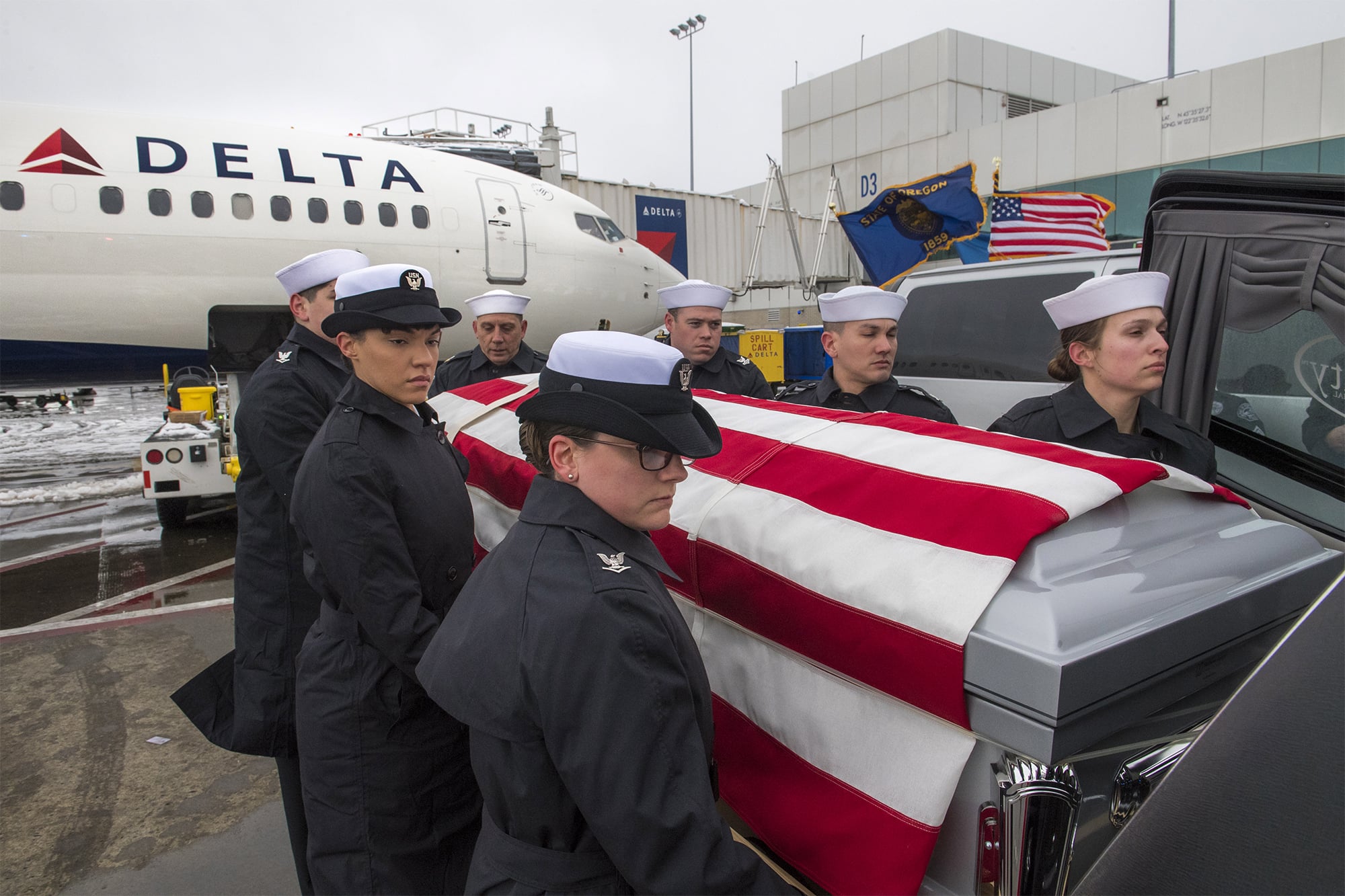 A military honor guard moves the body of Francis Dick from a Delta Airlines plane into a hearse while moving the casket from Portland International Airport to the Vancouver Funeral Chapel on Saturday, Feb. 9, 2019.