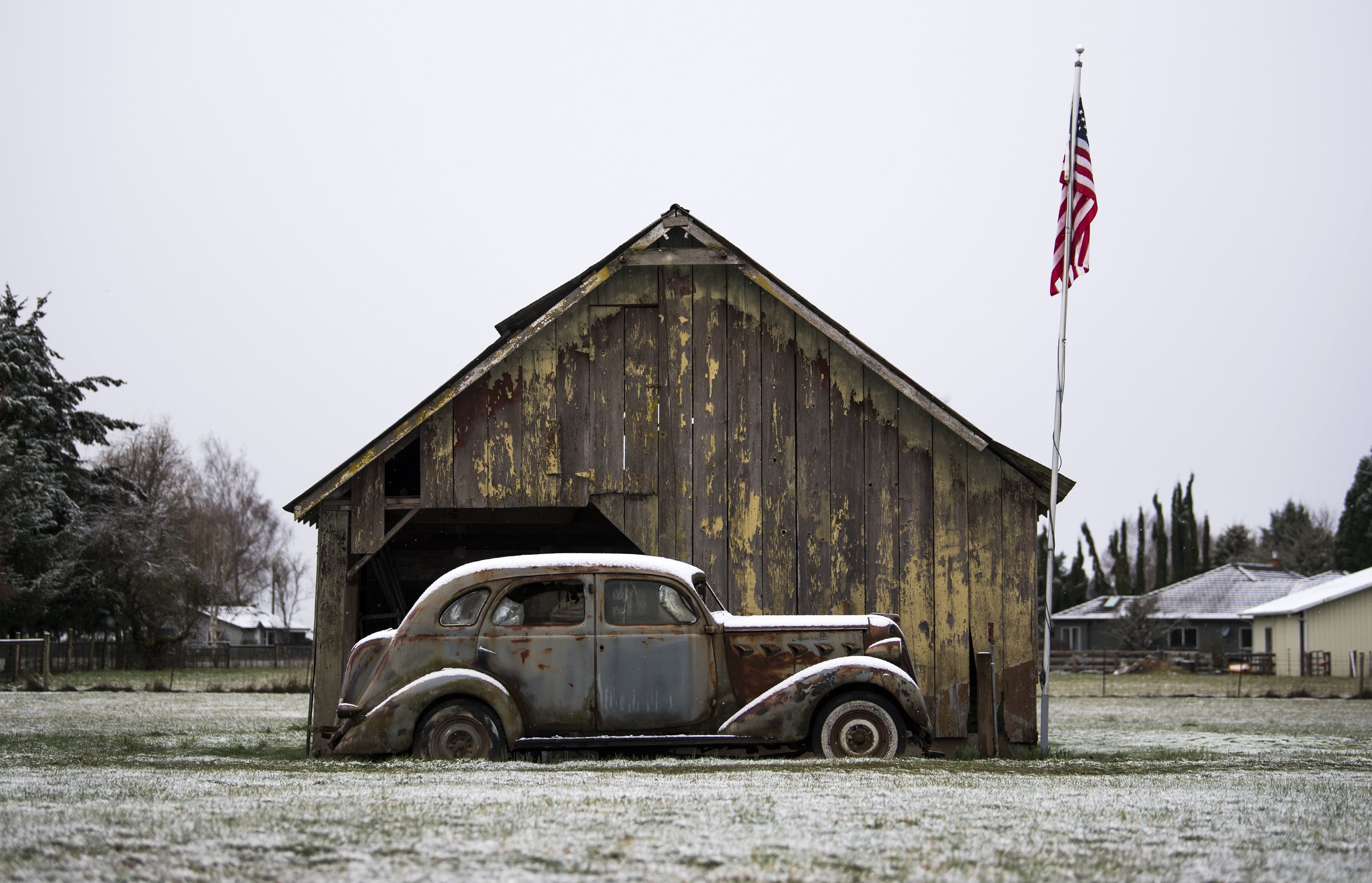 A dusting of snow rests on an old barn and car along NW 41st Avenue in Vancouver on Feb. 25, 2019.