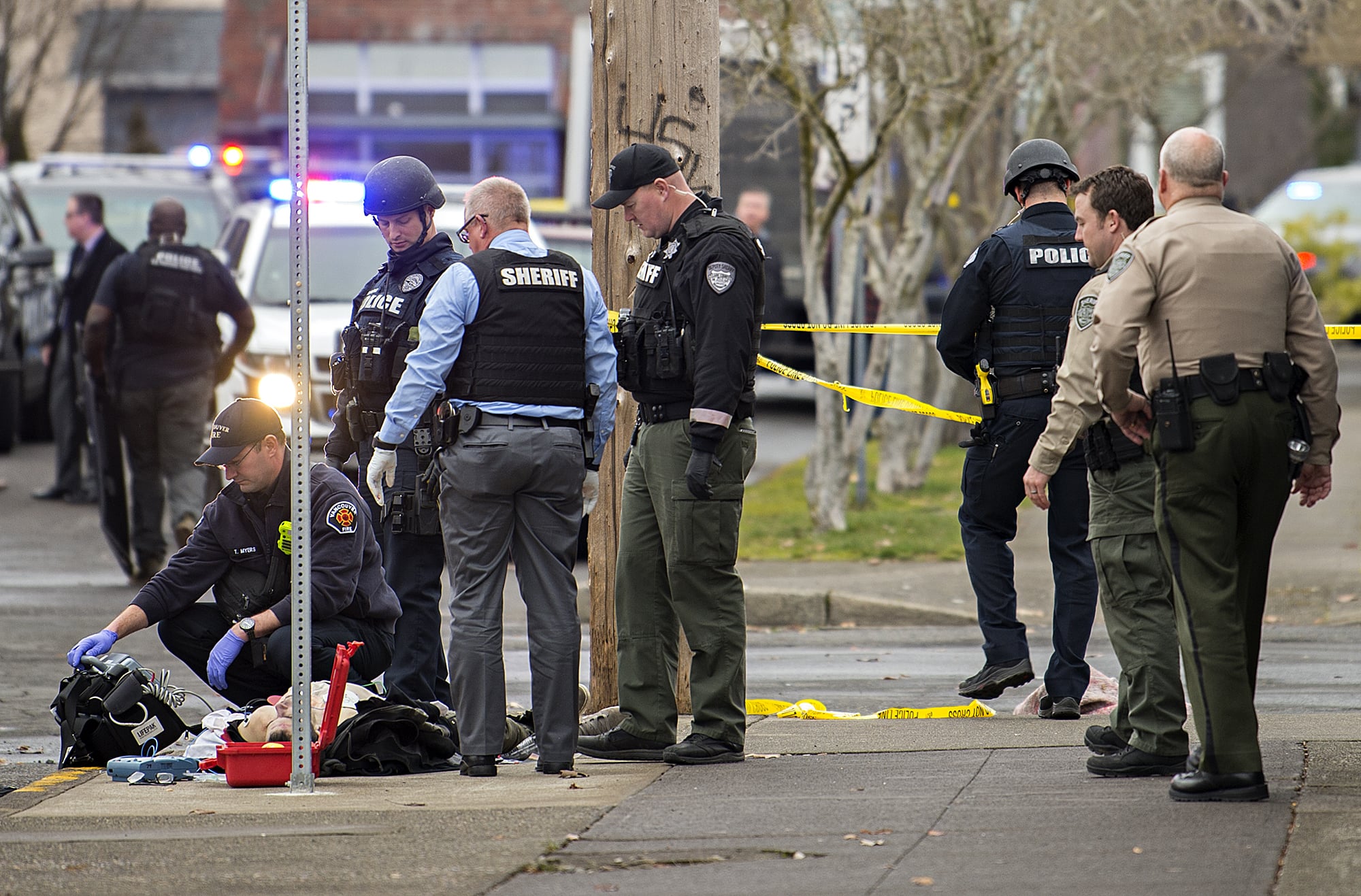 A Vancouver Fire Department paramedic checks for life signs on a man who was shot by police at the corner of West 12th Street and Jefferson Street in downtown Vancouver on Thursday afternoon, Feb. 28, 2019.