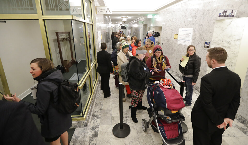 People line up in a hallway, Friday, Feb. 8, 2019, before a public hearing before the House Health Care &amp; Wellness Committee at the Capitol in Olympia, Wash. Amid a measles outbreak that has sickened people in Washington state and Oregon, lawmakers heard public testimony on a bill that would remove parents' ability to claim a philosophical exemption to opt their school-age children out of the combined measles, mumps and rubella vaccine. (AP Photo/Ted S.