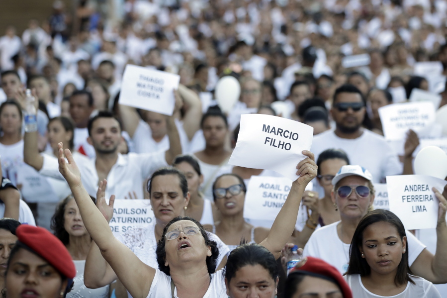 Friends and relatives hold signs with the names of victims, during a march paying homage to the victims of a mining dam collapse a week ago, in Brumadinho, Brazil, Friday, Feb. 1, 2019. A spokesman for the Minas Gerais Fire Department said after the ceremony that authorities were not calling off the search for bodies although no one had been found alive since Saturday.
