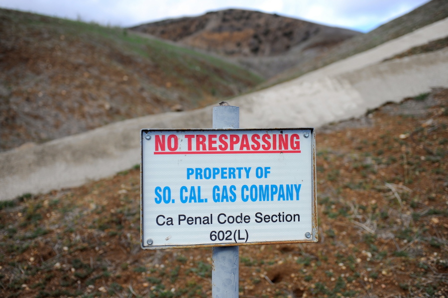FILE - In this Jan 7, 2016, file photo, a sign declares the boundary line of the Southern California Gas Company gas fields where a gas well leaked methane near the community Porter Ranch, Calif. A stink is being raised over a $120 million court settlement from the nation’s largest-known natural gas leak and it’s not about money, but cow manure. Environmental groups have criticized a plan to put more than a fifth of the settlement toward capturing climate-changing methane from dairy farms in California’s San Joaquin Valley.