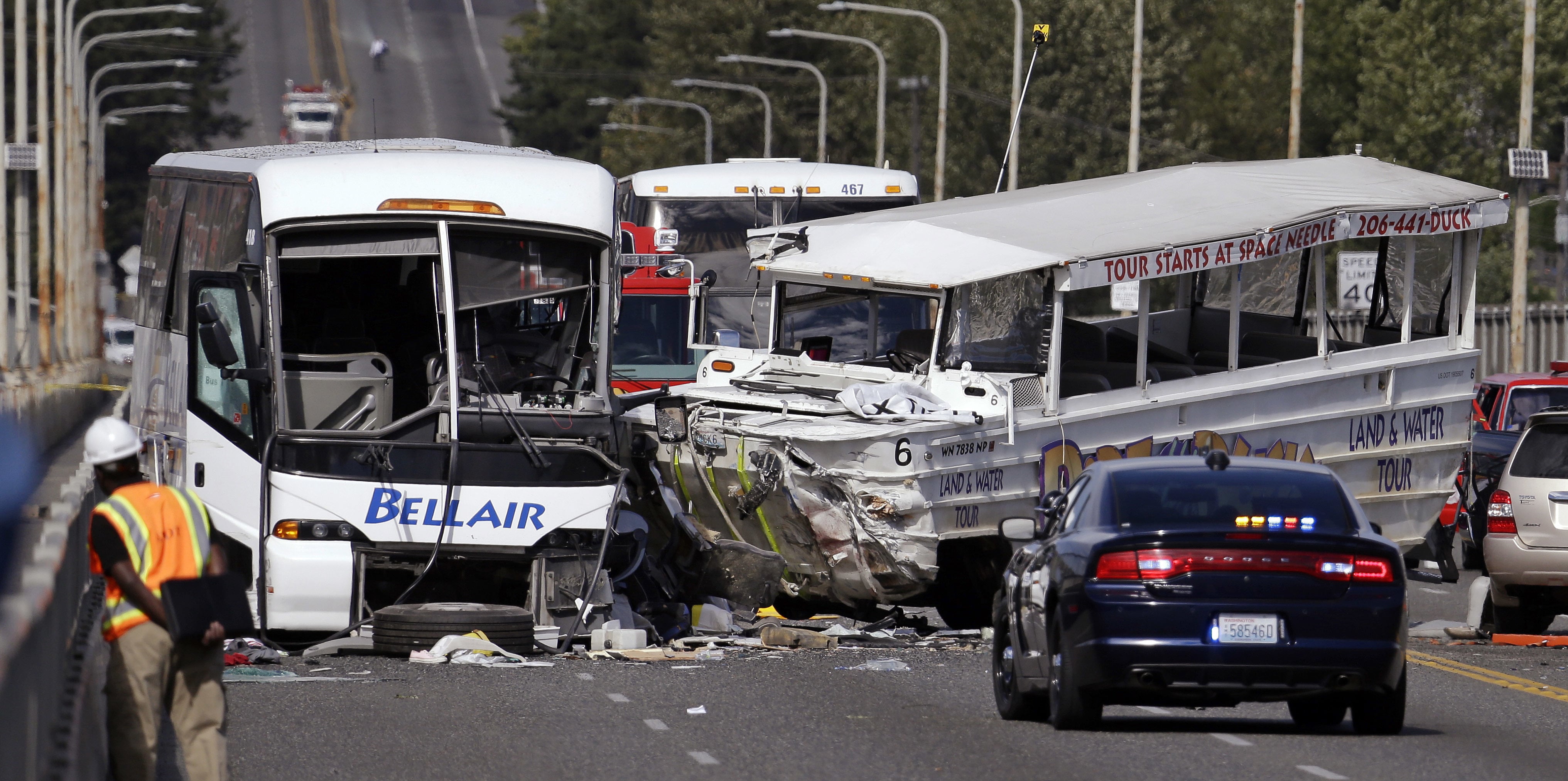 FILE - In this Sept. 24, 2015, file photo, a "Ride the Ducks" amphibious tour bus, right, and a charter bus remain at the scene of a multiple fatality collision on the Aurora Bridge in Seattle. A jury has awarded about $123 million to victims and families in a 2015 duck boat crash that killed five college students and wounded more than 60 others in Seattle. The Seattle Times reports Thursday, Feb. 7, 2019 that King County Superior Court jurors after a four-month civil trial found that Ride the Ducks International bore 67 percent of the responsibility for the crash, and tour vehicle operator Ride The Ducks of Seattle was 33 percent at fault.