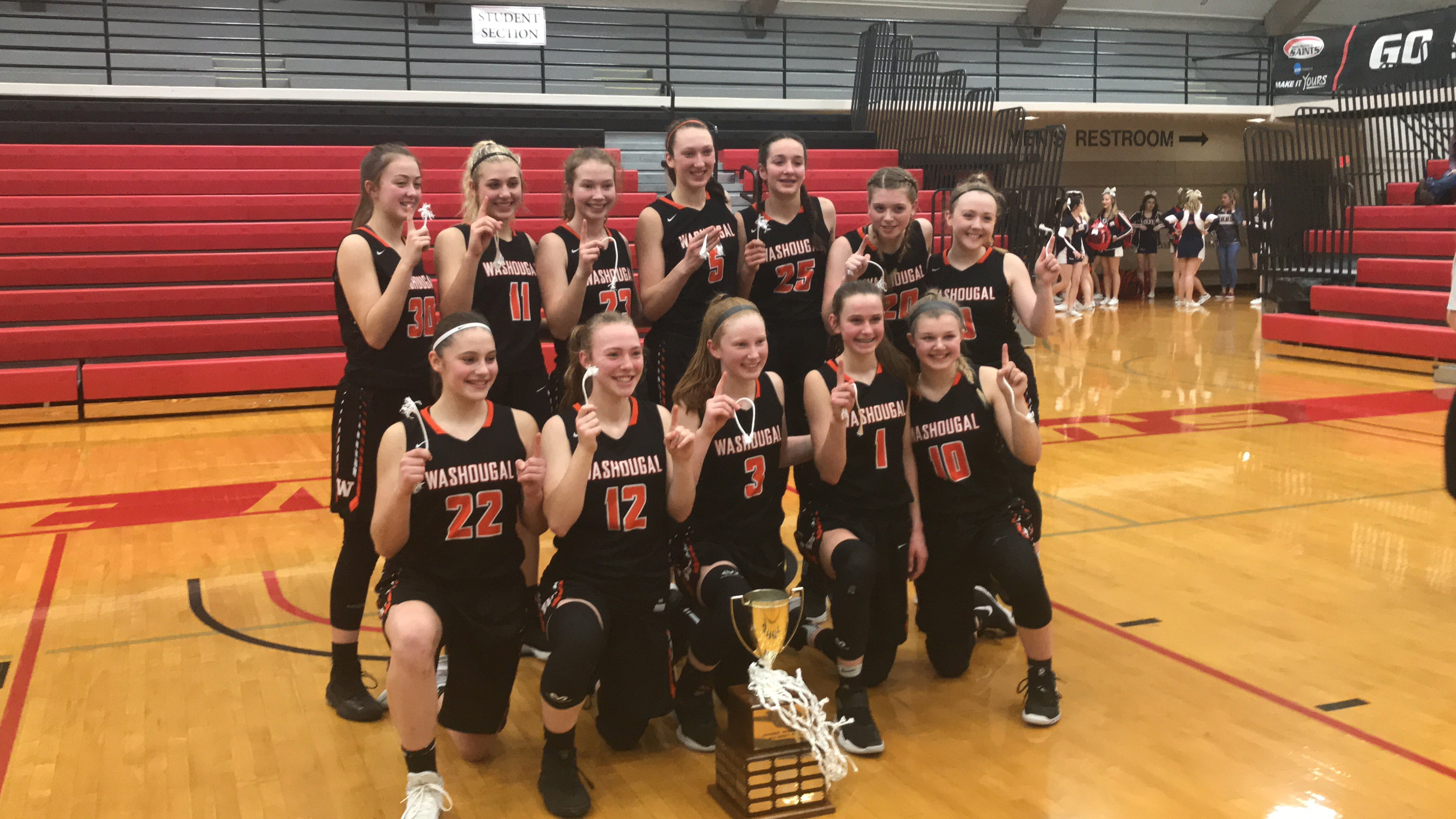 The Washougal girls basketball team pose with the district championship trophy after beating W.F.