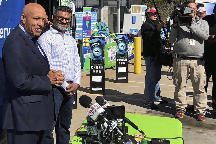 South Carolina Education Lottery Chief Operating Officer Tony Cooper, left, and KC Mart owner CJ Patel, right, speaks to reporters about the winning ticket sold at the Simpsonville, S.C., store on Oct. 24.