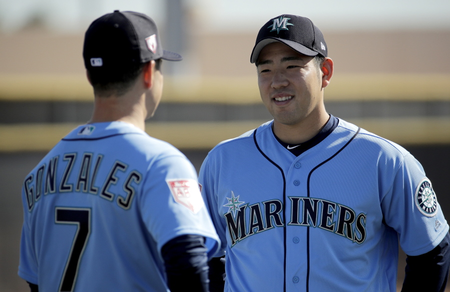 Seattle Mariners pitcher Yusei Kikuchi, from Japan, talks to pitcher Marco Gonzales during spring training baseball practice Tuesday, Feb. 12, 2019, in Peoria, Ariz.