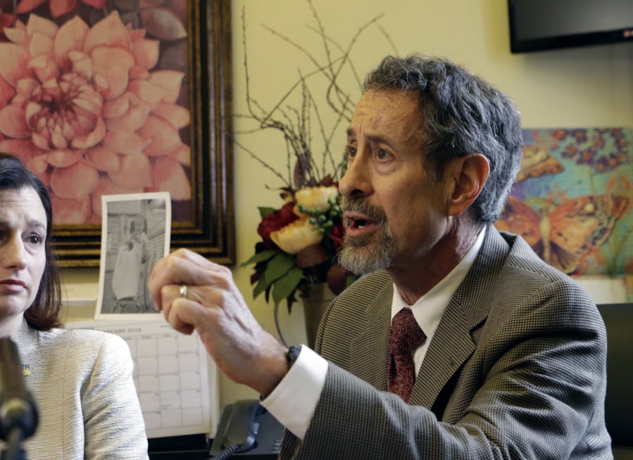 Dr. Gary Goldbaum of the Washington State Medical Association holds up a picture of his brother as a child, when he was in a wheelchair due to polio, at Wednesday’s hearing on a vaccination bill.