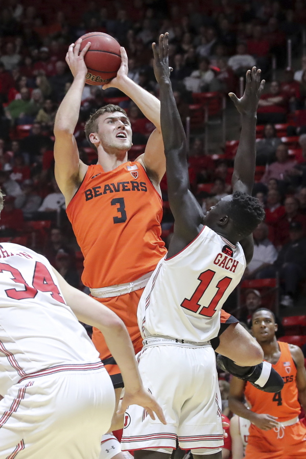 Oregon State forward Tres Tinkle (3) looks over the arms of Utah forward Both Gach (11) while shooting during the first half of an NCAA college basketball game Saturday, Feb. 2, 2019, in Salt Lake City.