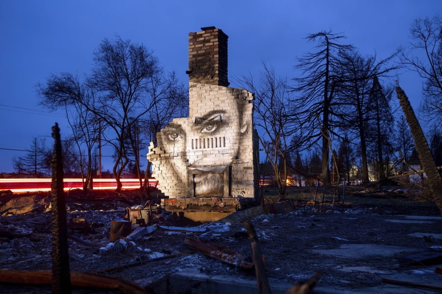 In this Feb. 8, 2019, photo, a mural by artist Shane Grammer adorns the chimney of a residence leveled by the Camp Fire in Paradise, Calif. Grammer says he painted murals throughout the fire-ravaged town to convey hope in the midst of destruction. In the 100 days since the wildfire nearly burned the town of Paradise off the map, the long recovery is just starting.