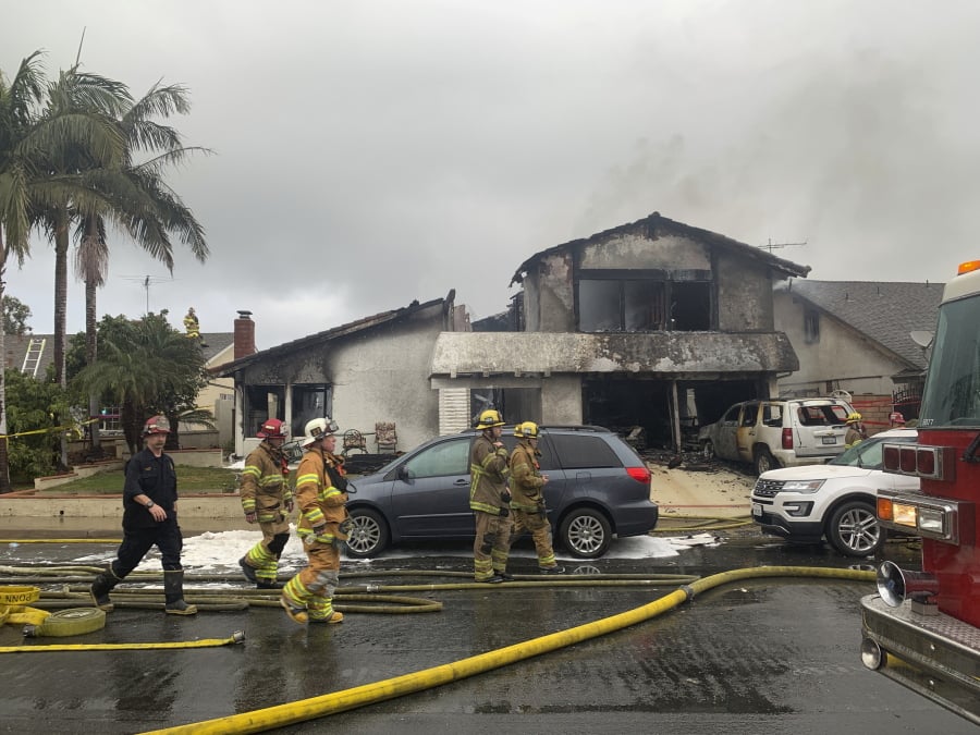 Firefighters respond to the scene of a plane crash at a home in Yorba Linda, Calif., Sunday, Feb. 3, 2019. A twin-engine Cessna 414A crashed in Yorba Linda shortly after taking off from the nearby Fullerton Municipal Airport. The Orange County Fire Authority said the crash in a Yorba Linda neighborhood ignited a fire that burned the house Sunday afternoon.