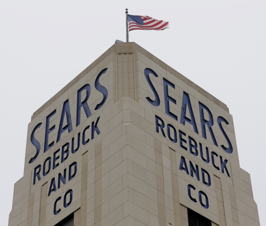 FILE- In this Jan. 8, 2019, file photo an American flag flies above a Sears store in Hackensack, N.J. A bankruptcy judge has blessed a $5.2 billion plan by Sears chairman and biggest shareholder Eddie Lampert to keep the iconic business going. The approval means roughly 425 stores and 45,000 jobs will be preserved.