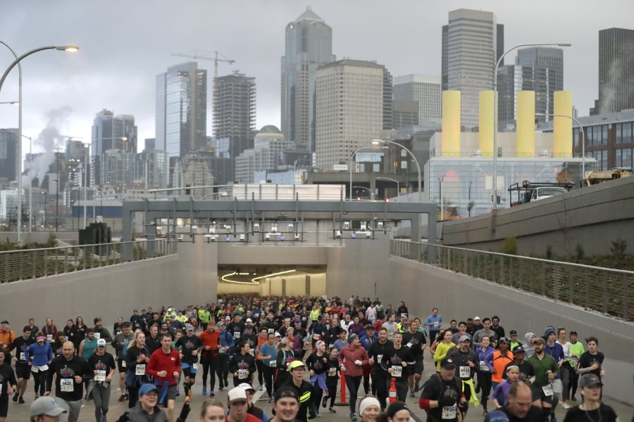 Thousands of runners emerge from the new tunnel that will replace the Alaskan Way Viaduct in downtown Seattle as they take part in an 8k run to mark the planned Monday grand opening of the tunnel, Saturday, Feb. 2, 2019. Seattle began a three-day goodbye party Saturday for the aging, double-decker viaduct that's served as a main artery for commuters for decades. (Ted S.