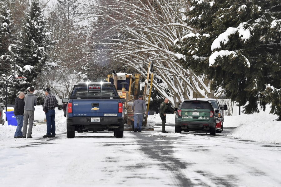 In this Wednesday, Feb. 13, 2019 photo, Spokane County Sheriff’s deputies respond to a call where a Spokane County plow driver said a local man brandished a firearm and told him to step out of his plow in Spokane, Wash. Unusually heavy snow in the Spokane area has caused snow plow rage: Two plow drivers clearing streets this week were threatened by people enraged after their driveways ended up blocked with mounds of snow.