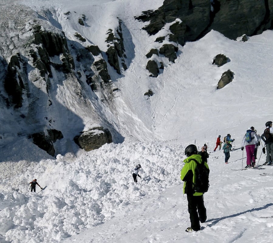 Rescue crews work at the site of an avalanche in the ski resort of Crans-Montana, Switzerland, on Tuesday. Swiss mountain rescue teams pulled out four people who were buried Tuesday at the popular ski resort and were searching for others, police said.