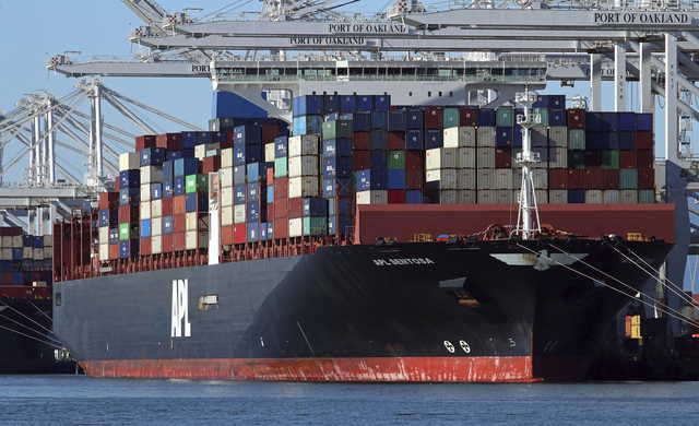 In this Dec. 6, 2018, file photo container ships docked at the Port of Oakland are unloaded on Thursday, Dec. 6, 2018, in Oakland, Calif. On Wednesday, Feb. 6, the Commerce Department reports on the U.S. trade gap for November.