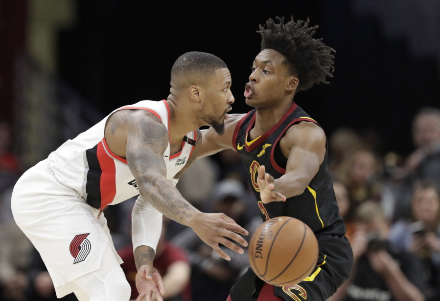 Portland Trail Blazers' Damian Lillard, left, passes against Cleveland Cavaliers' Collin Sexton in the second half of an NBA basketball game, Monday, Feb. 25, 2019, in Cleveland. Portland won 123-110.