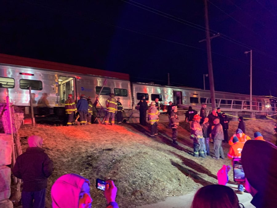 First responders work the scene of a collision involving a Manhattan-bound commuter train and a vehicle in Westbury, N.Y., Tuesday, Feb. 26, 2019. The Long Island Rail Road says service was suspended Tuesday evening in both directions on the Ronkonkoma and Huntington/Port Jefferson branches.