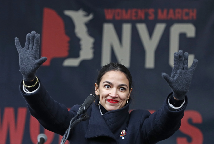 FILE - In this Jan. 19, 2019, file photo, U.S. Rep. Alexandria Ocasio-Cortez, (D-New York) waves to the crowd after speaking at Women’s Unity Rally in Lower Manhattan in New York. Democrats including Ocasio-Cortez of New York and veteran Sen. Ed Markey of Mass. are calling for a Green New Deal intended to transform the U.S. economy to combat climate change and create jobs in renewable energy.