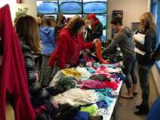 Players and parents search over tennis clothing during the Vancouver Tennis Center Foundation gear swap on Sunday, March 3, 2019. The 2020 gear swap is Sunday, March 8.